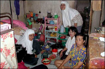 This single room is home to three Adidas shoe factory workers. The back door leads to the communal bathroom, kitchen and laundry facilities. These living conditions are typical for all shoe and garment factory workers in Tangerang.